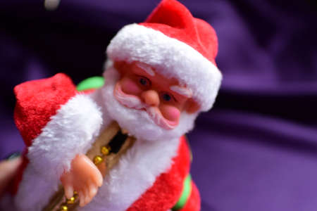 Santa claus doll on a purple background. Close-up.の写真素材