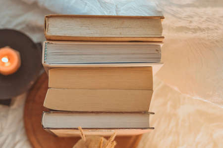 Stack of books with a candle on the bed. Selective focus.の写真素材