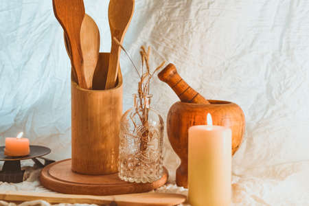 Wooden kitchen utensils in a vase on a light backgroundの写真素材