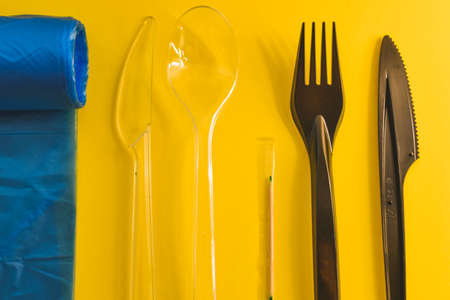 Disposable plastic tableware on yellow background. Plastic waste concept.の写真素材