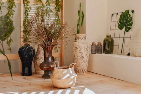 Stylish interior design of modern living room with wooden floor, stylish rattan vases and plants.の写真素材