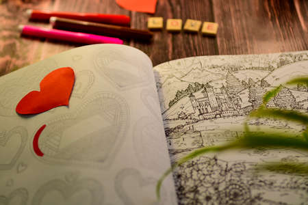 drawing boog for valentine day with red paper heart on wooden background. High quality photoの写真素材