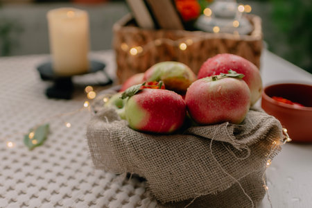 basket of apples on a table in a cozy room with candles
