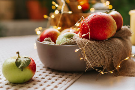 Christmas composition with apples in bowl on wooden background. Selective focus.の写真素材