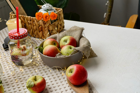 Ripe apples in a basket on a white table in a rustic settingの写真素材