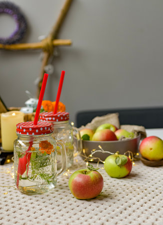 Mason jar with apple juice and fresh apples on white tableclothの写真素材