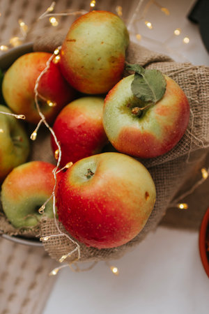 Apples in a basket with a garland on a light backgroundの写真素材