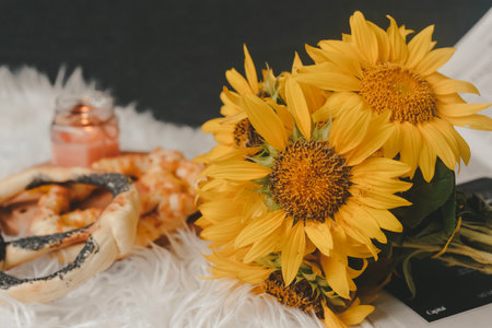wedding rings and bouquet of sunflowers on white furの写真素材