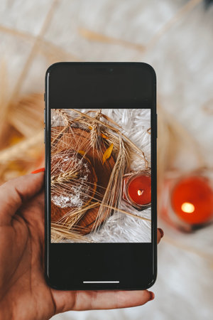 Woman hand taking photo of christmas gingerbread cookies with smartphone.の写真素材
