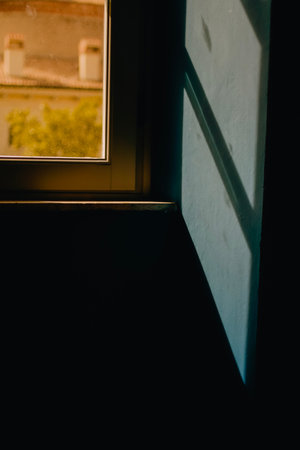 A vertical shot of a window with a light coming through the windowの写真素材