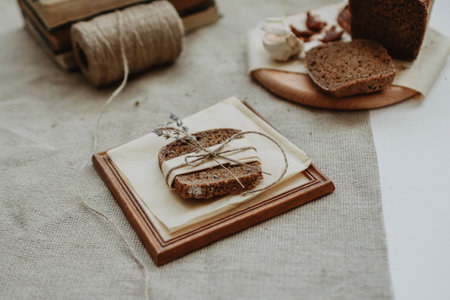 Bread on wooden board with linen napkin on rustic backgroundの写真素材