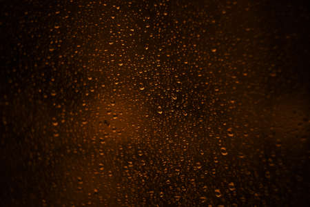 Raindrops on the window glass, and through the windows was a hazy night view.