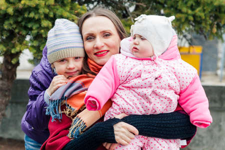 Happy mother walks with two daughtersの写真素材