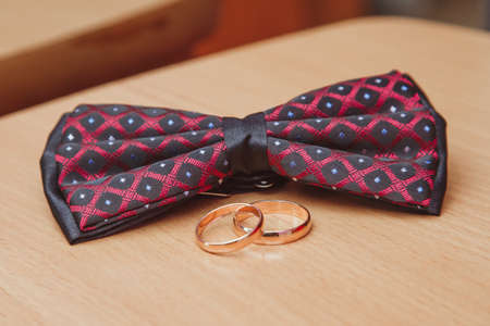 Wedding rings and bow ties on tableの写真素材
