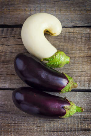Three eggplants on an old wooden tableの写真素材