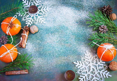 Winter Christmas decorations - tangerines, walnuts, snowflakes, cinnamon and candles. with space for textの写真素材