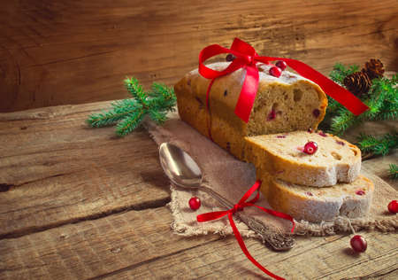 Christmas cake with cranberries on the background of fir branchesの写真素材