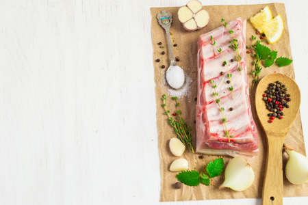 Pork ribs on a white background, with spices and herbs preparedの写真素材