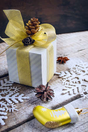 Christmas box with a gift decorated with golden bow, pine cones and snowflakes. tintedの写真素材