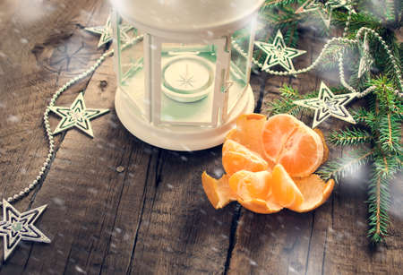 Christmas composition: lantern, candle, tangerine, garland and spruce branches. Toned imageの写真素材