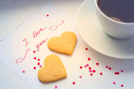 Declaration of love, a cup of coffee and cookies in the shape of a heart.の写真素材