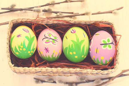 Painted Easter eggs in a wicker box on a white background. tintedの写真素材