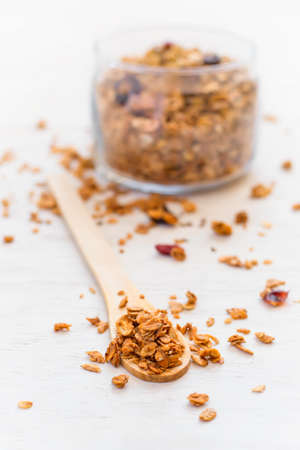 Healthy breakfast. Granola in a wooden spoon on a white backgroundの写真素材
