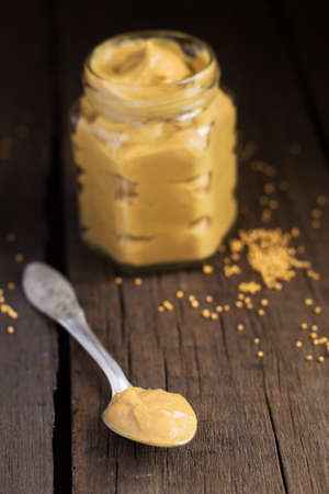 Homemade mustard sauce on the old wooden background, selective focusの写真素材