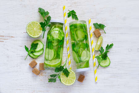 Background homemade lemonade bottles, cucumber, lime and brown sugarの写真素材