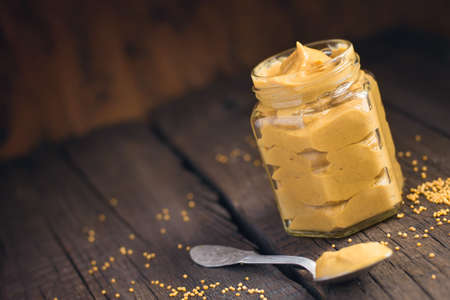 HomeMade mustard sauce in a jar on a dark background.の写真素材