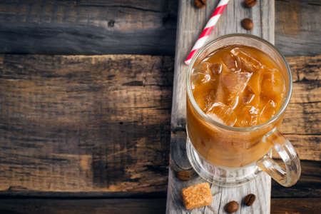Coffee with ice in a glass, selective focus, top view, space for text