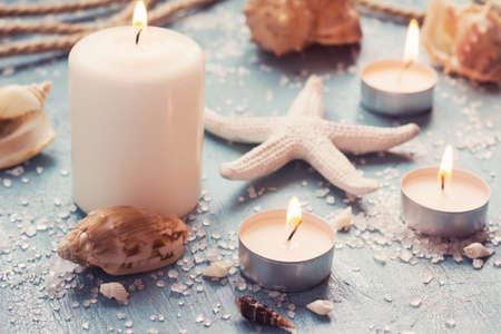 Burning candles and marine items, tinted in pastel colors.の写真素材