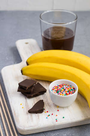Ingredients for Banana Pops on a white cutting board.の写真素材