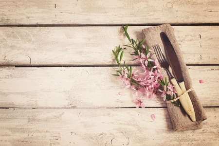 Spring table setting with almond flowers and cutlery, vintage toningの写真素材