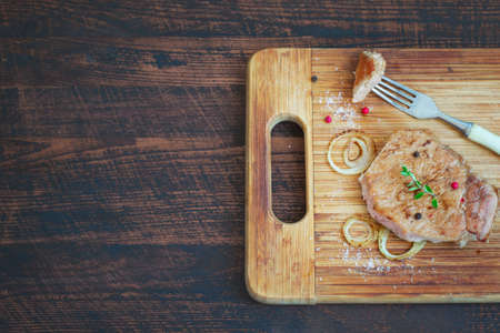 Roasted meat on the old bamboo board. Top view with copy space.の写真素材