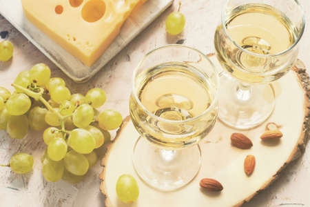Glasses of white wine and grapes and nuts, tinted.の写真素材