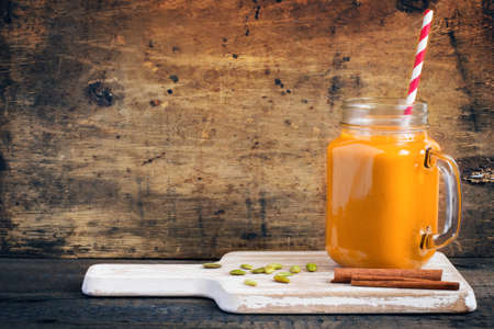 Healthy pumpkin smoothie with cinnamon and pumpkin seeds, vintage toning, copy spaceの写真素材