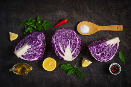 Halved red cabbage on dark background. Ingredients for vegetarian salad. Top view.