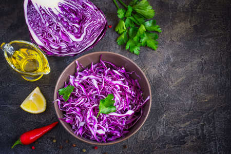 Purple cabbage salad and ingredients on a dark background. Top view with copy spaceの写真素材