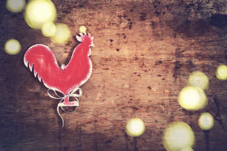 Vintage background with a homemade toy Rooster. Vintage symbol of the year. Tinted.の写真素材