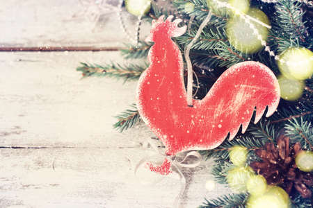 Festive Christmas vintage background with a homemade toy Rooster. Tinted.