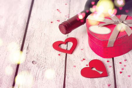 St. Valentine's day background with red wine and a gift, tinted.の写真素材
