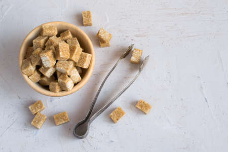 Brown sugar in a wooden bowl. Top view with copy space.の写真素材
