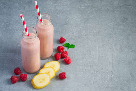 Raspberry banana milk smoothies in bottles, copy spaceの写真素材