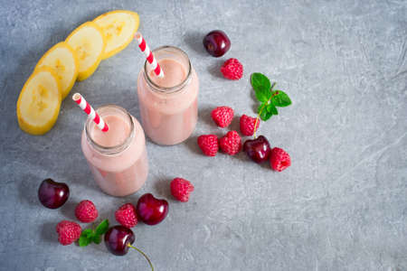 Smoothie with banana, raspberry and cherry. Top view with copy spaceの写真素材