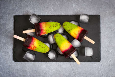 Colorful layer ice cream on a stick made from natural fruit. Top viewの写真素材