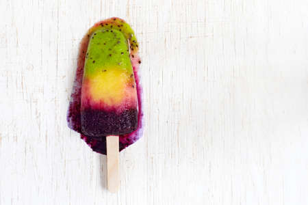 Colorful layer natural fruit ice cream on a stick. Top view with copy spaceの写真素材