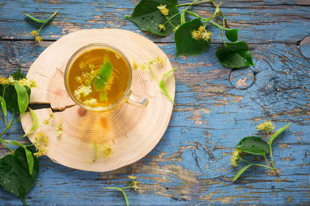 Cup with linden tea and flowers. concept of treatment cold and flu. Top view with copy spaceの写真素材