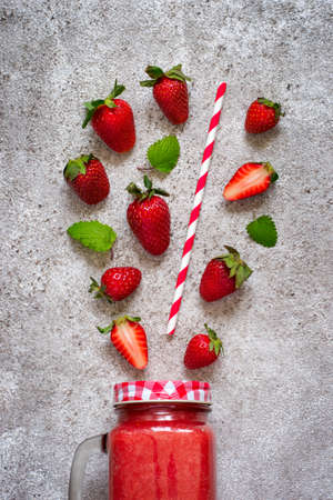 Healthy natural red smoothies made from ripe strawberries in a glass jar and ingredients. Top viewの写真素材