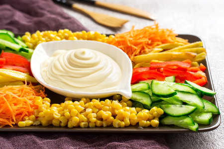 Homemade mayonnaise sauce. Dish with set of colorful vegetables. Russian salad goat in the garden....